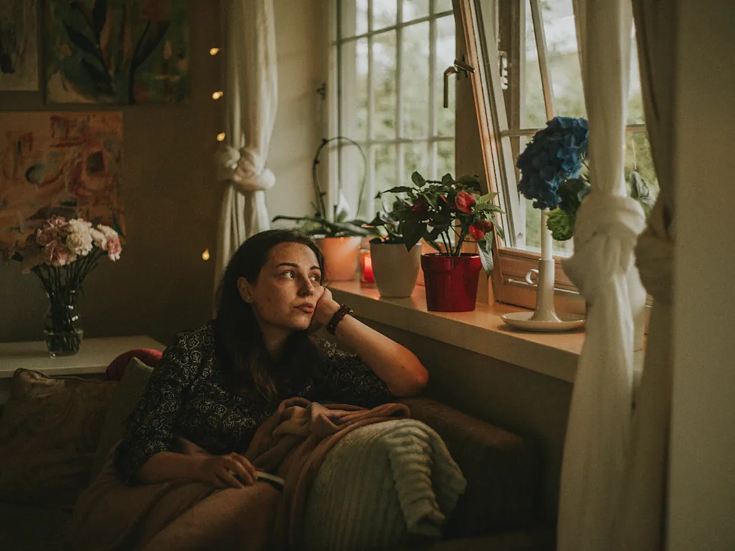 Woman sitting quietly by a window at home