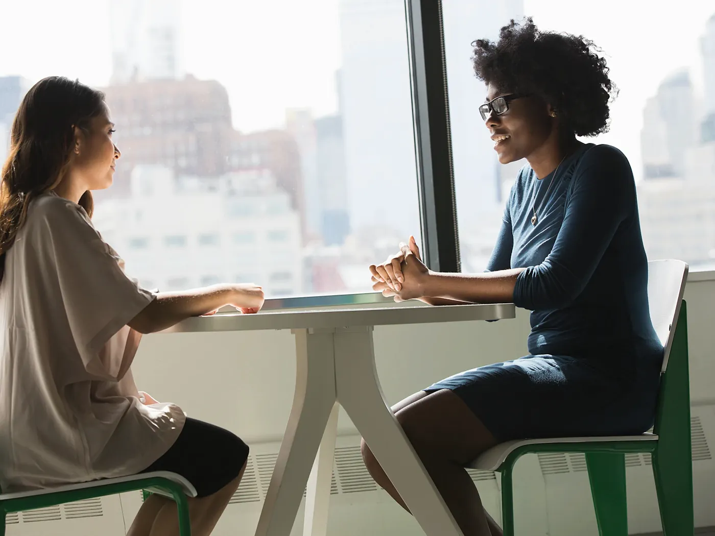 Two women talking warmly across a table