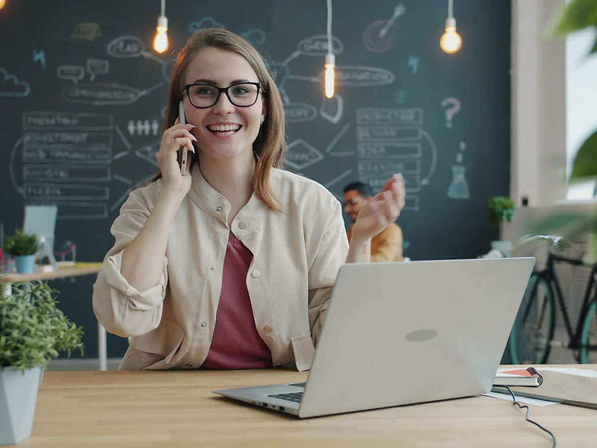 Smiling care coordinator on the phone at her desk